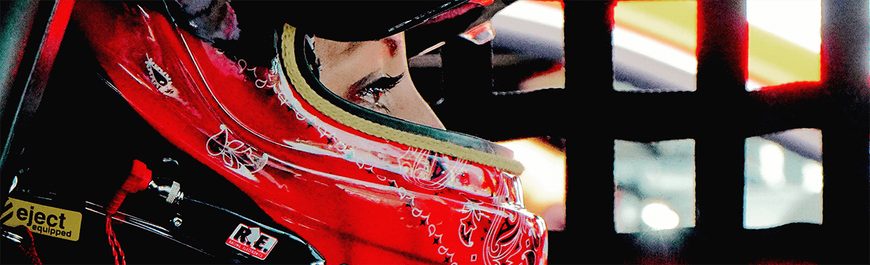 Closeup of racecar driver wearing a helmet in a racecar