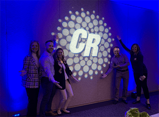 The JRT team with the New Clear Rate logo displayed in lights at the client's town hall meeting.