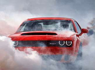 Red Dodge Challenger SRT Hellcat smoking its tires