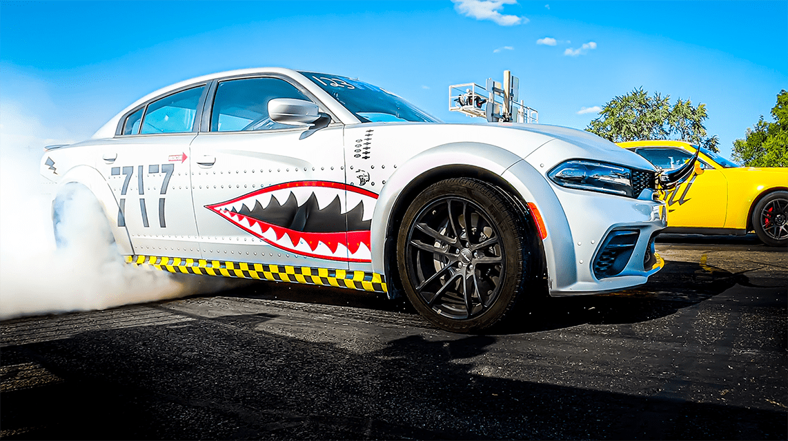 Dodge Charger SRT Hellcat with custom-painted sharp teeth on its door smoking its tires