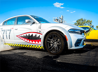 Dodge Charger SRT Hellcat with custom-painted sharp teeth on its door smoking its tires