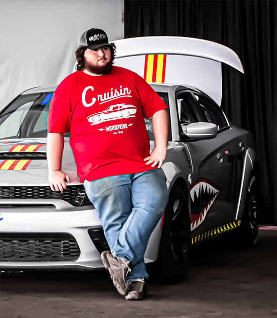 Man leaning on a customized Dodge Charger SRT Hellcat