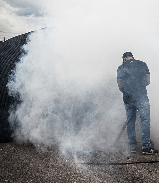 Man standing on racetrack surrounded by smoke
