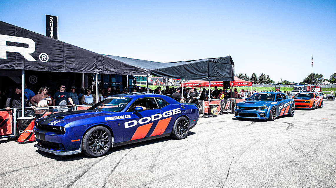 Crowd of enthusiasts looking at custom Dodge street racing cars
