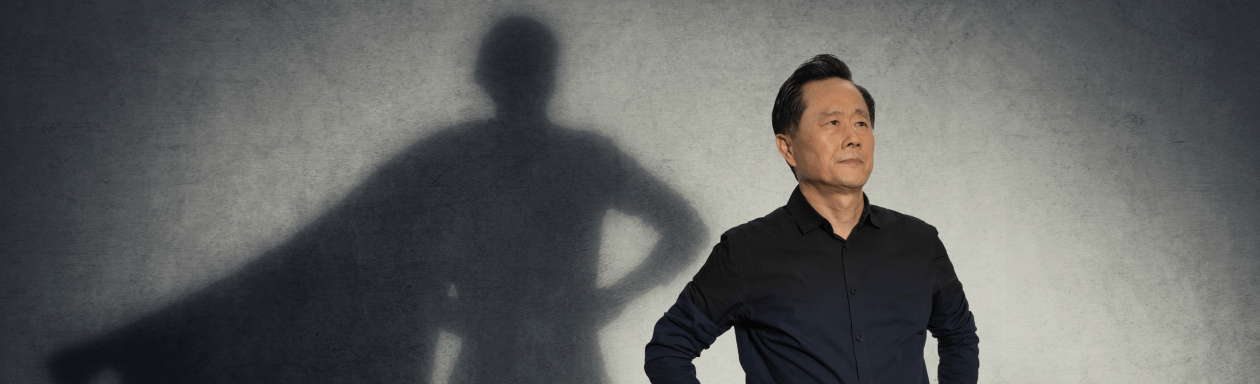 Man posing as superhero with shadow