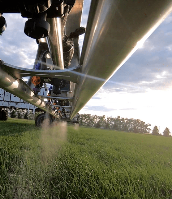 Closeup of autonomous farming equipment spraying field