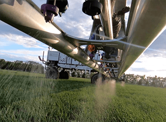 Closeup of autonomous farming equipment spraying field