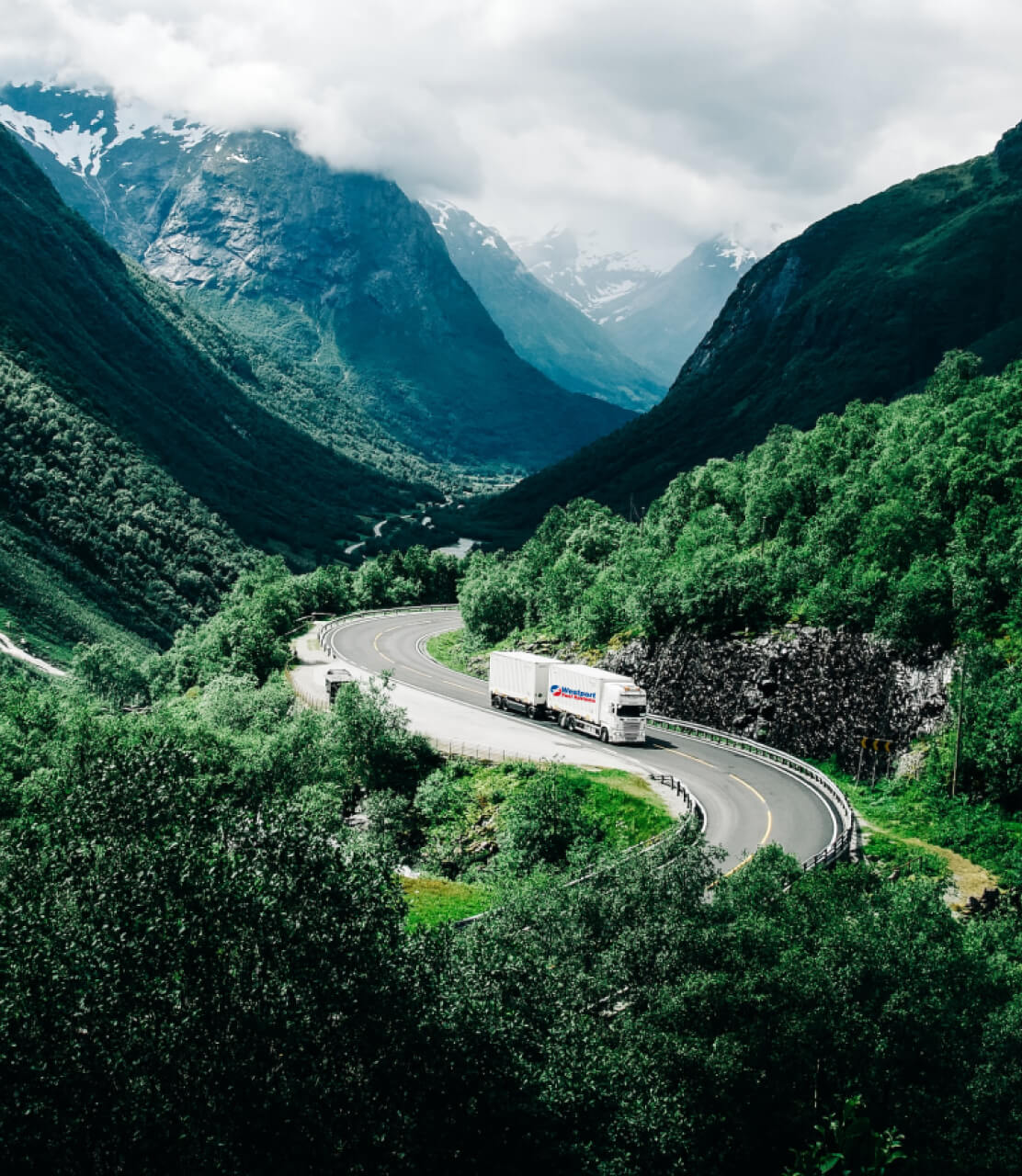 Truck driving down a road in mountains