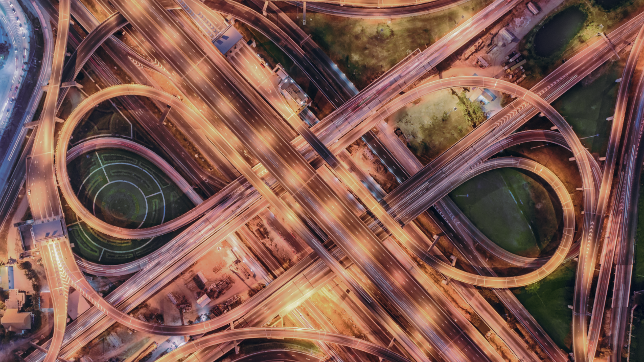 An aerial view of a bustling highway system, with loops and lights galore.