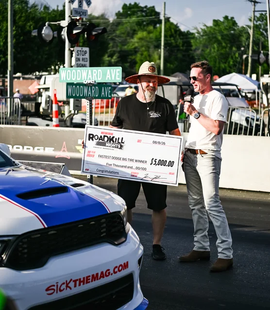 Roadkill Nights race official holding a winner sign